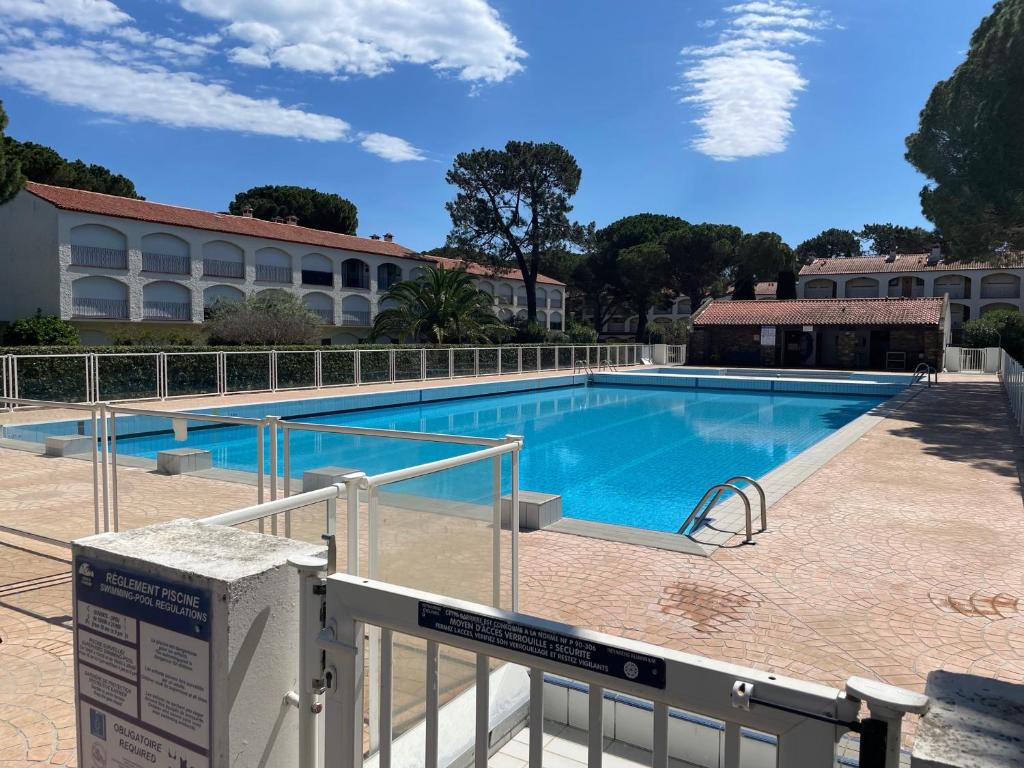 une grande piscine avec un bâtiment en arrière-plan dans l'établissement Appartement cosy proche mer avec piscine et tennis à Argelès sur Mer - FR-1-309-458, à Argelès-sur-Mer