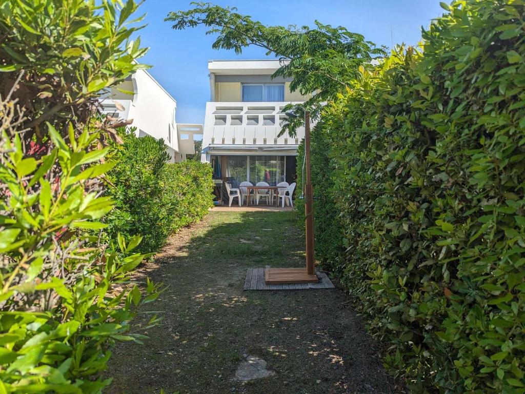 - une vue sur la maison depuis le jardin dans l'établissement Duplex en bord de mer avec jardin privé et accès direct à la plage, climatisation, parking et internet. - FR-1-250-282, à La Grande Motte