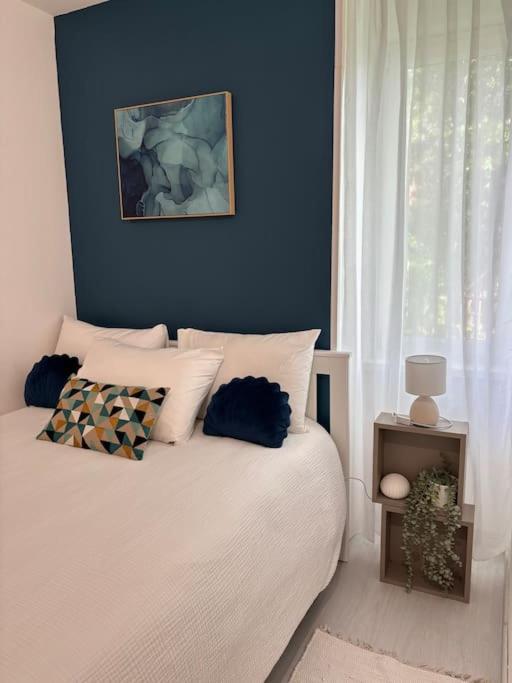 une chambre avec un lit blanc avec une fenêtre dans l'établissement Appartement tout équipé Centre Mulhouse, à Mulhouse
