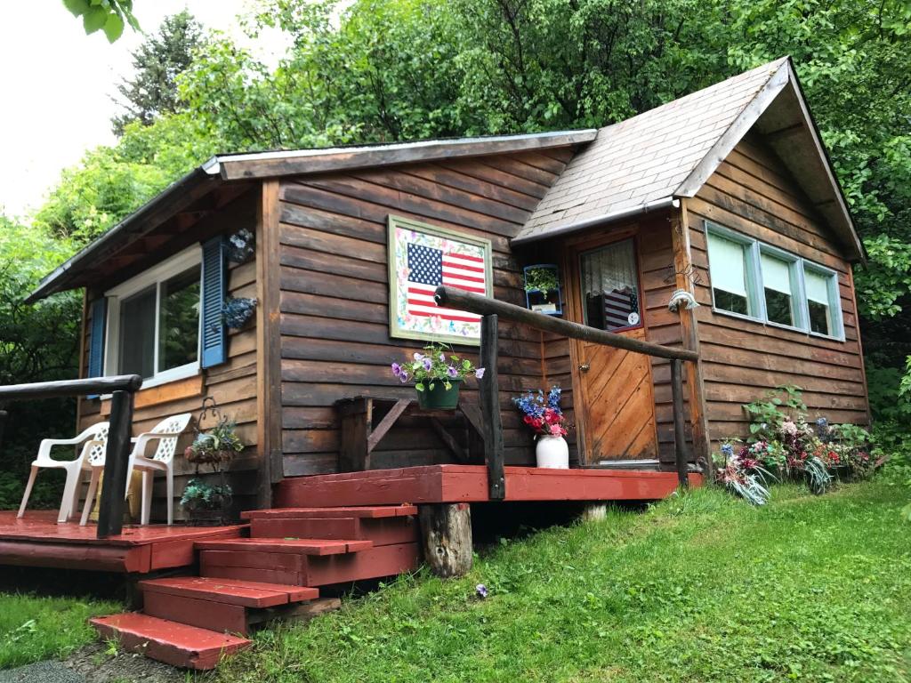 a tiny house with a porch and stairs at Homestead cabin in Homer