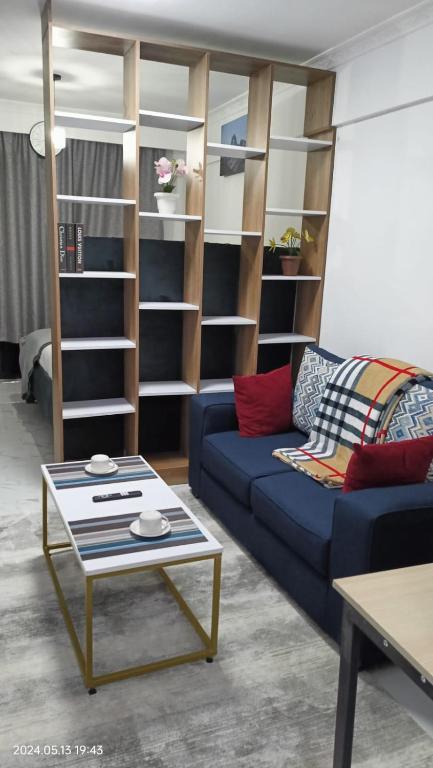 a living room with a blue couch and a coffee table at SmartHomes A1406 SmartHomes in Nairobi