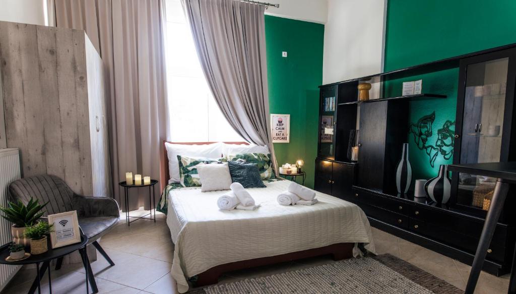 a bedroom with a bed and a green wall at Cozy studio Anastasia-spotless-quiet-Free private garage in Kozani