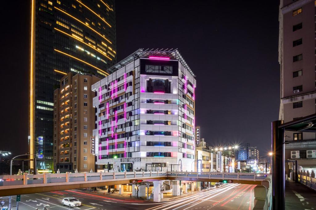 um edifício alto com um relógio na lateral em Calligraphy Greenway Hotel em Taichung
