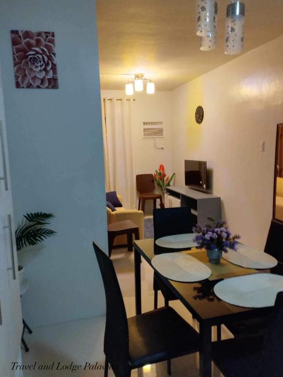 a room with a table and chairs and a living room at Travel and Lodge Palawan in Puerto Princesa City