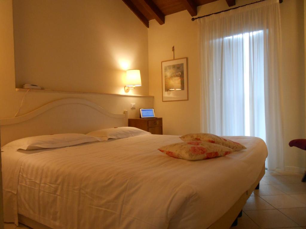 sypialnia z białym łóżkiem i oknem w obiekcie Hotel Atlantic w Bolonii