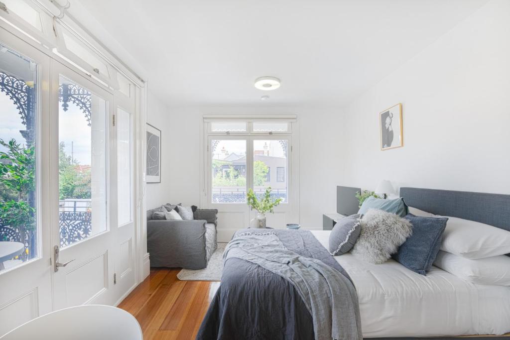 Camera bianca con letto e divano di Not your usual studio apartment a Sydney