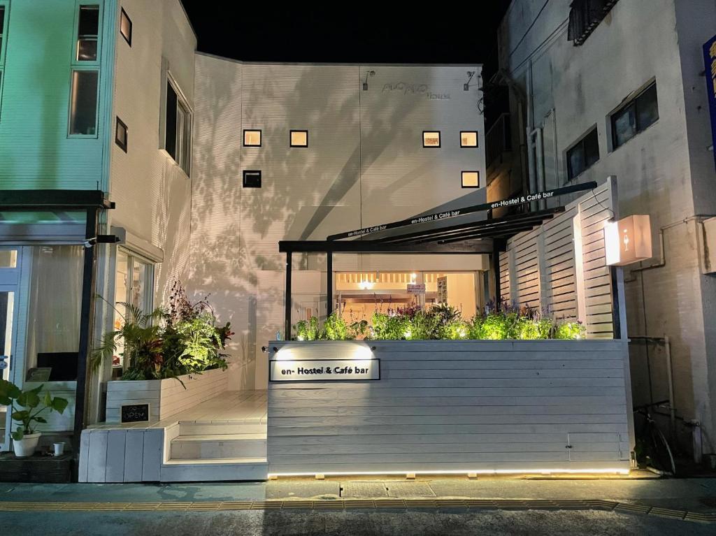 Un edificio con una jardinera con plantas en él. en En- Hostel & Café bar, en Amami