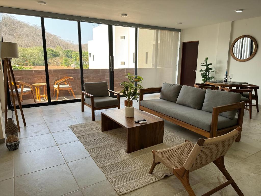 a living room with a couch and a table and chairs at Nabani Condominios T1 in Santa Cruz Huatulco