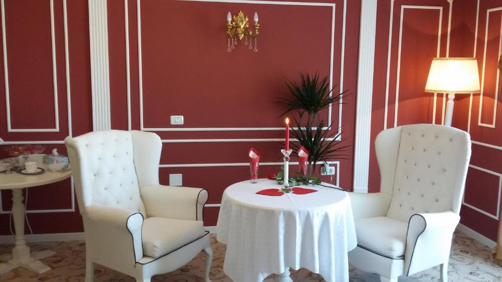 a dining room with two chairs and a table with candles at Conacul din Ardeal in Braşov