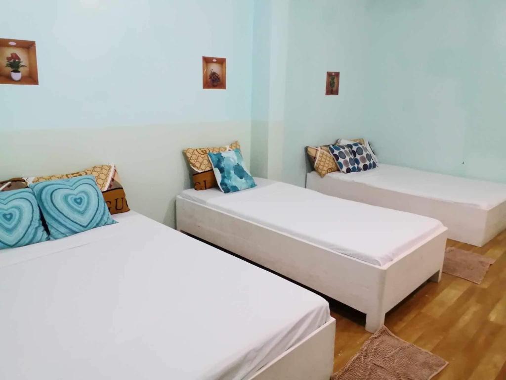a room with two beds and a couch at Pearls Z Apartelle in Boracay