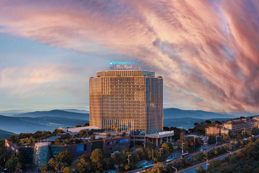 a tall building with a blue sign on top of it at Wyndham Grand Plaza Royale Chenzhou in Chenzhou