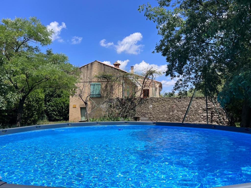 une grande piscine bleue devant une maison dans l'établissement villa avec piscine et grand jardin, à Nîmes