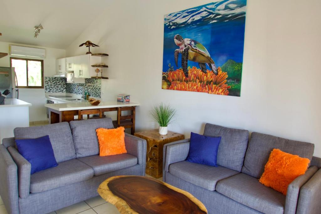 a living room with two couches and a table at Coral Reef Condo in Coco