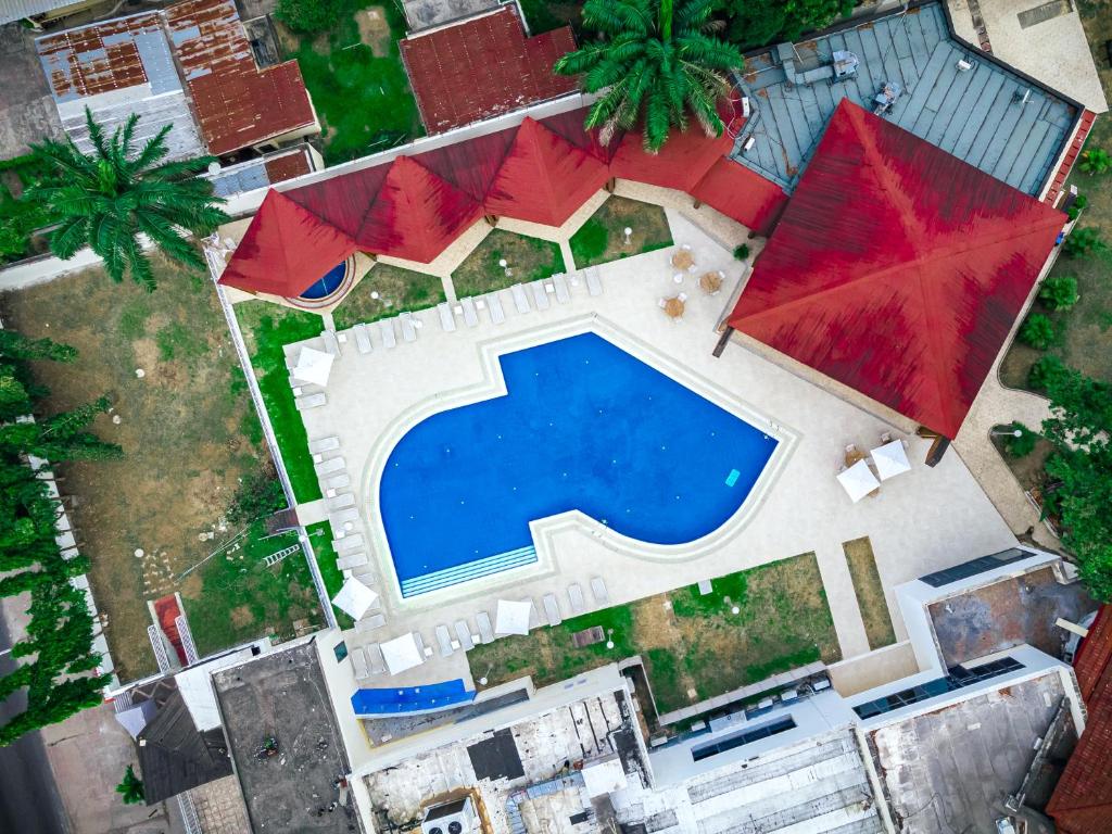 an overhead view of a swimming pool with red umbrellas at Grand Lancaster Brazzaville in Brazzaville