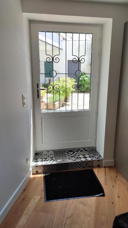 une porte avec un portail dans une pièce avec un étage dans l'établissement Maison de ville, à La Flotte