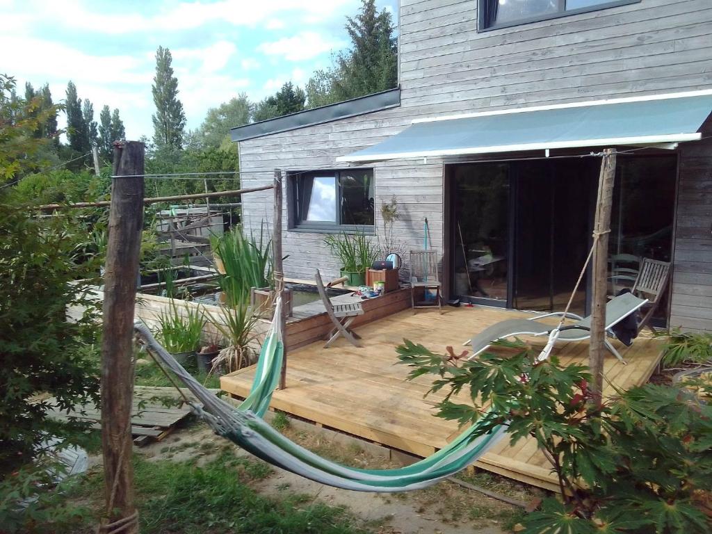 - une terrasse avec un hamac dans une maison dans l'établissement Maison bois mer campagne, à Saint-Jean-Trolimon