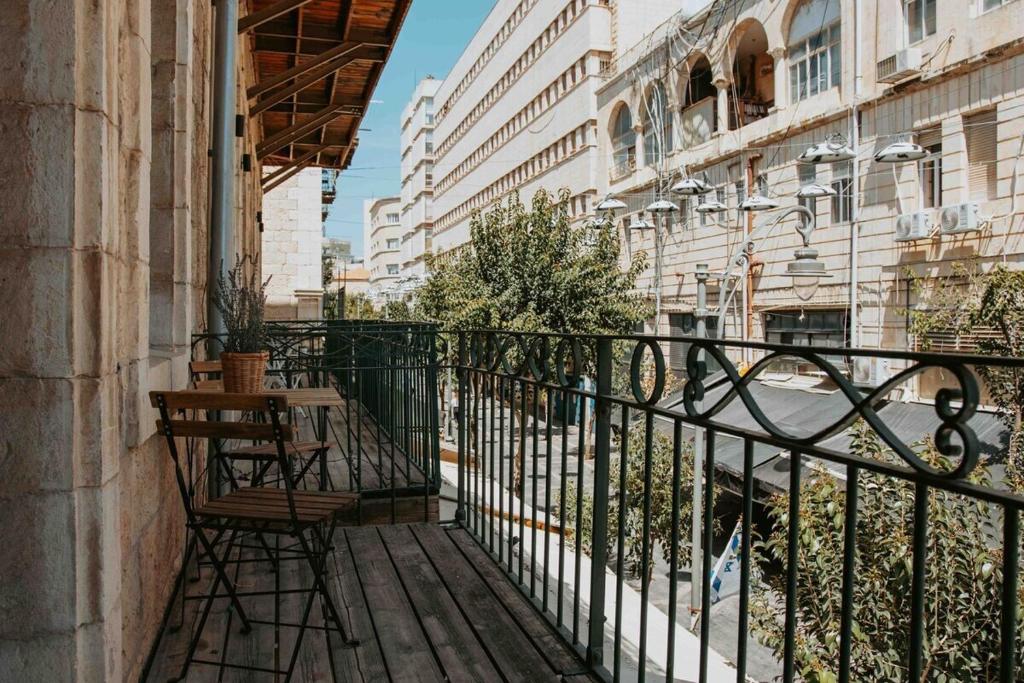 un balcon avec une table et des chaises sur un immeuble dans l'établissement New Duplex - Next mamila, à Jérusalem