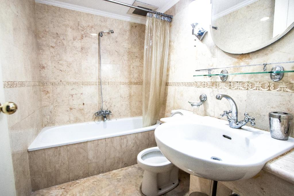 a bathroom with a sink and a toilet and a tub at Batavia Apartment ST in Jakarta