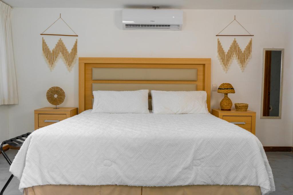 sypialnia z dużym białym łóżkiem ze złotymi akcentami w obiekcie Equinoccio Hotel w mieście Santa Ana
