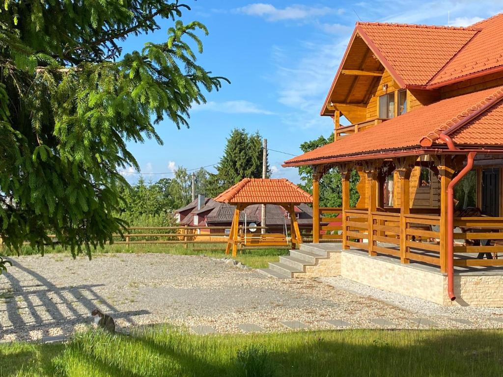 a wooden pavilion with a gazebo next to a house at Cabana Magura Mare Belis in Călăţele