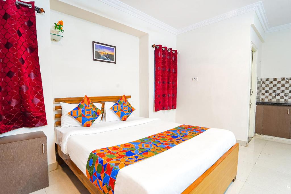 a bedroom with a bed in a room with red curtains at FabExpress Mann Pasand Inn in Bangalore