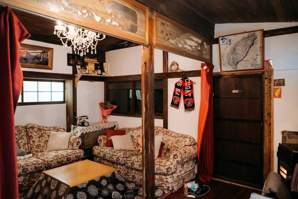a living room with two couches and a chandelier at CASA DE YOSHi 一棟貸し in Yamagata