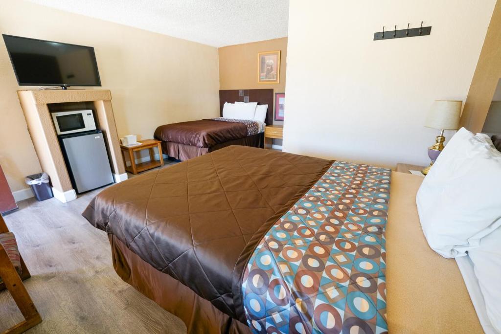 ペイソンにあるRim Country Inn Paysonの大型ベッドとテレビが備わるホテルルームです。