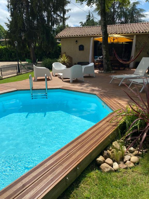 une piscine avec une terrasse en bois et un patio dans l'établissement Le Loft, à Port-Sainte-Foy-et-Ponchapt