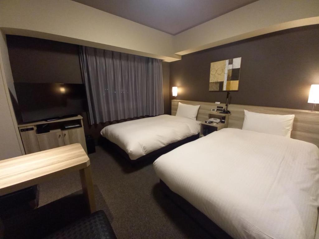 Postel nebo postele na pokoji v ubytování Hotel Route-Inn Yamanashi Chuo