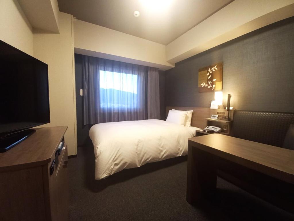 Postel nebo postele na pokoji v ubytování Hotel Route-Inn Yamanashi Chuo