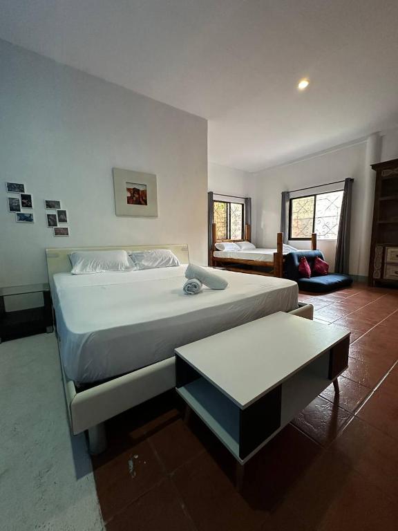 a bedroom with a large bed and a table at VitaminSea Room in Dauin