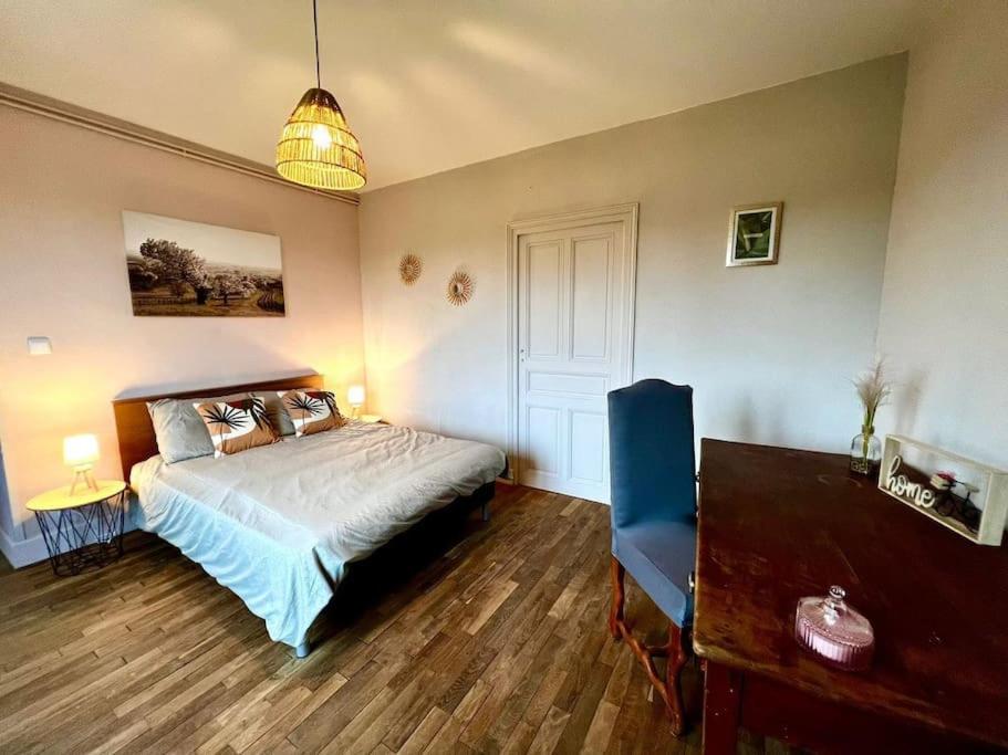 une chambre avec un lit, une table et un bureau dans l'établissement Gîte de Pierrot, à Vicq