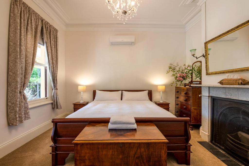 a bedroom with a large bed and a fireplace at Bon Accord Luxury Accommodation in Sale