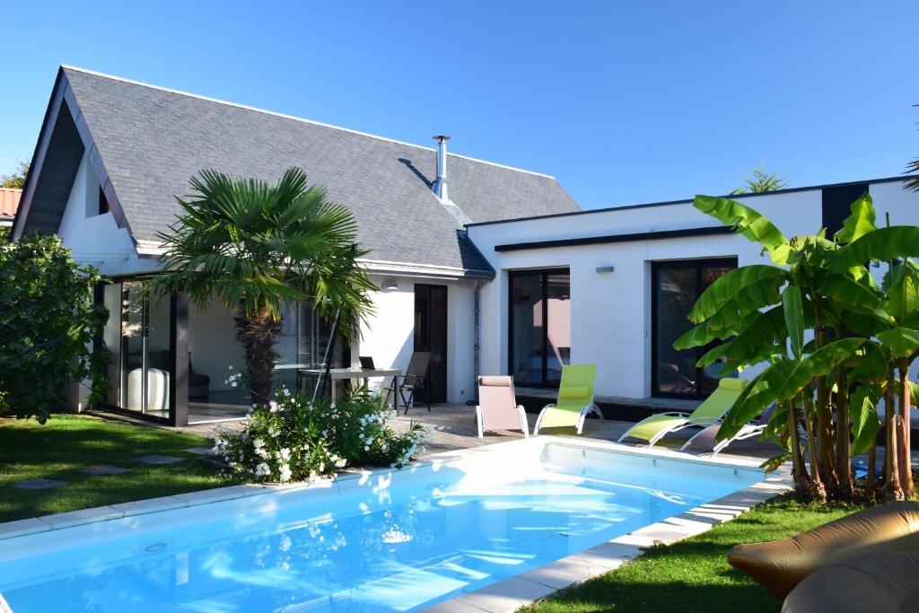 une piscine devant une maison dans l'établissement Villa plage piscine chauffée, à La Bernerie-en-Retz