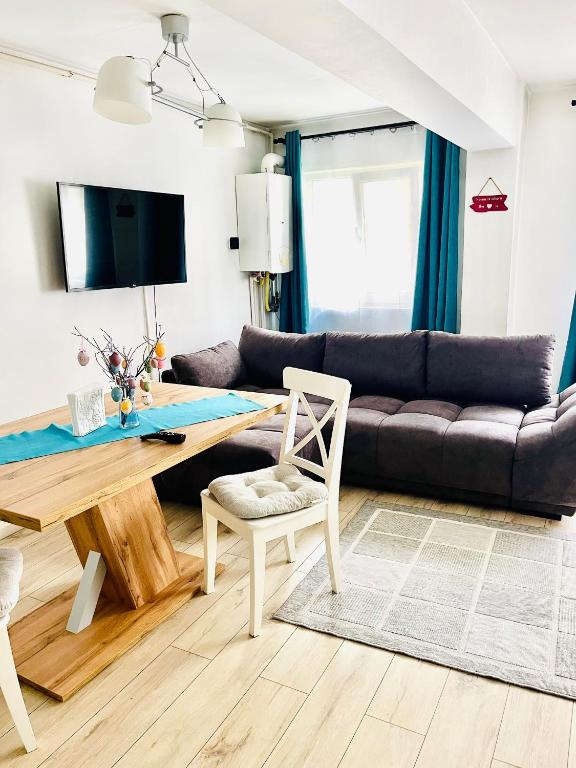 a living room with a table and a couch at Petrosani Central ApartHotel in Petroşani