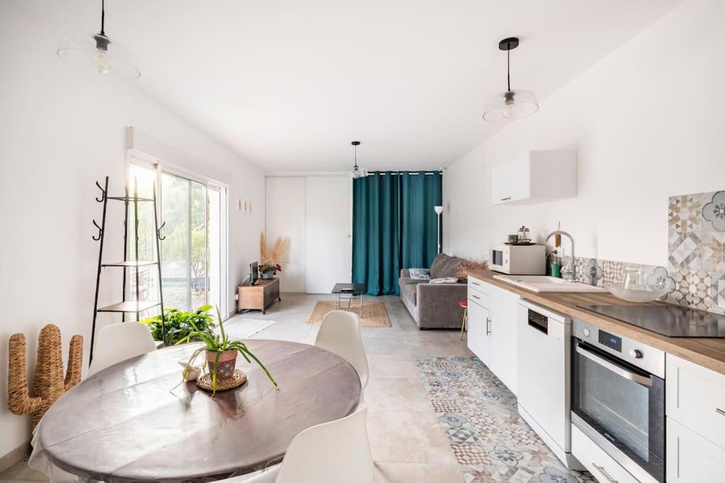 une cuisine avec une table et une salle à manger dans l'établissement sublime appart terrasse piscine privee jardin, à Aubagne