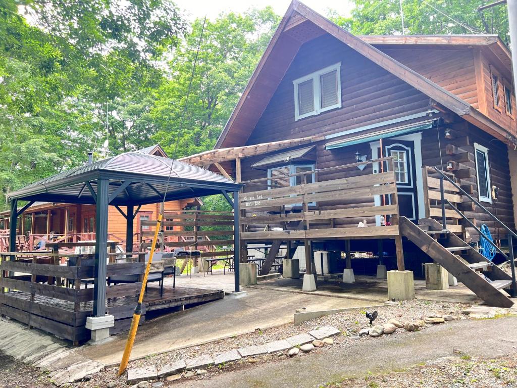 una casa di legno con un ombrello di fronte di コテージLog a Nasu