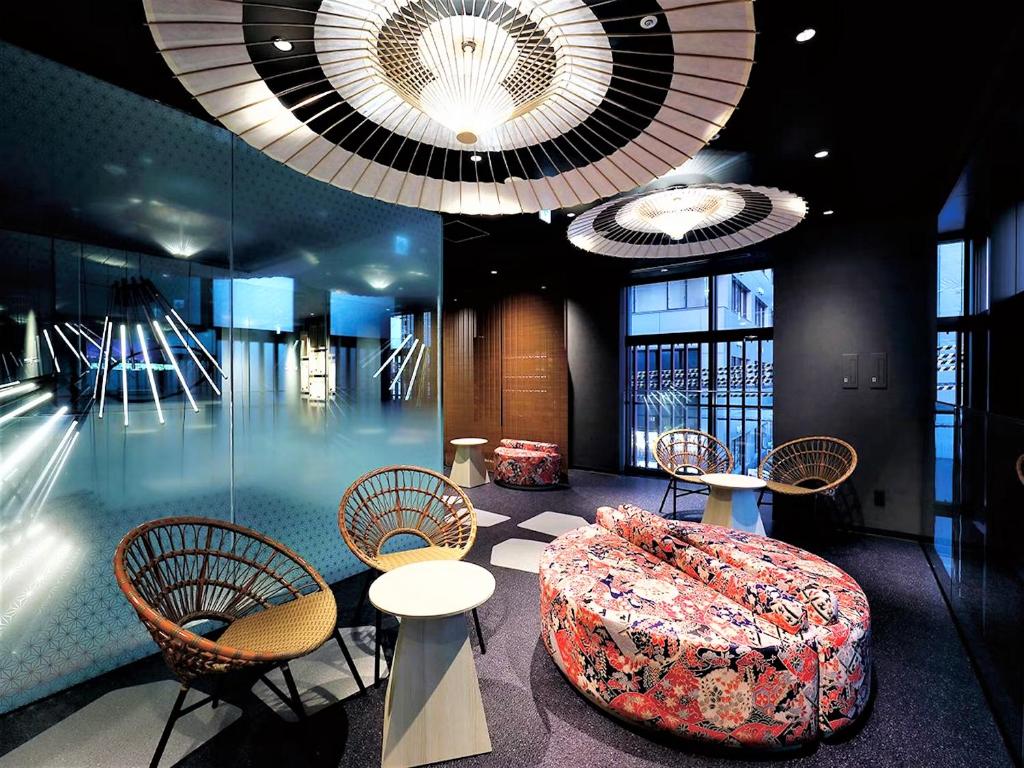 a lobby with tables and chairs and large chandeliers at Daiwa Roynet Hotel KANAZAWA-MIYABI in Kanazawa