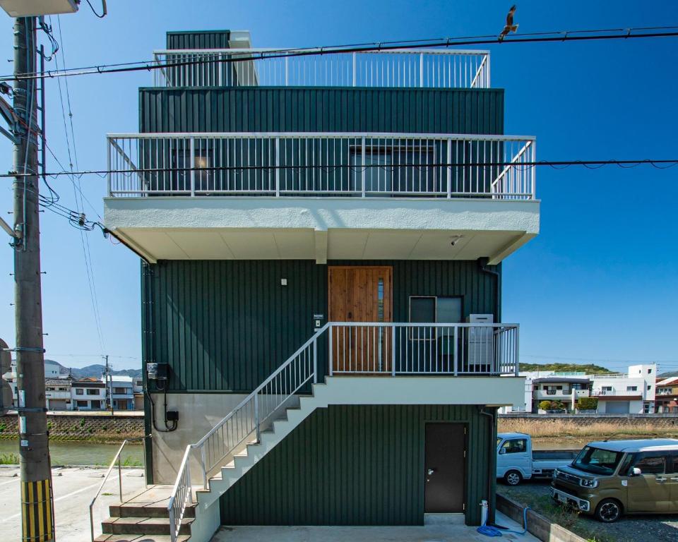 a green building with a staircase on the side of it at MusicInn Matoya - Vacation STAY 88768v in Sumoto
