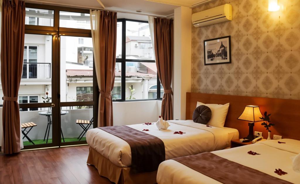 Postel nebo postele na pokoji v ubytování Hanoi Win Hotel & Travel