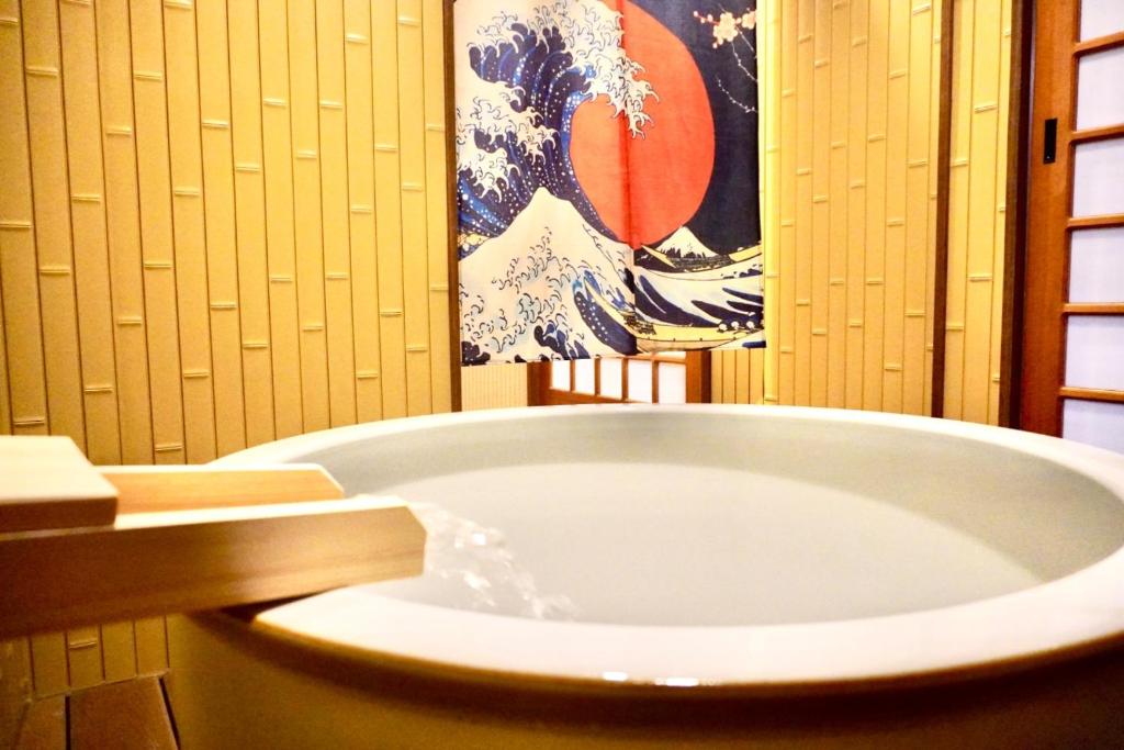a bath tub in a bathroom with a painting on the wall at Karin Housu - Vacation STAY 82851v in Takayama