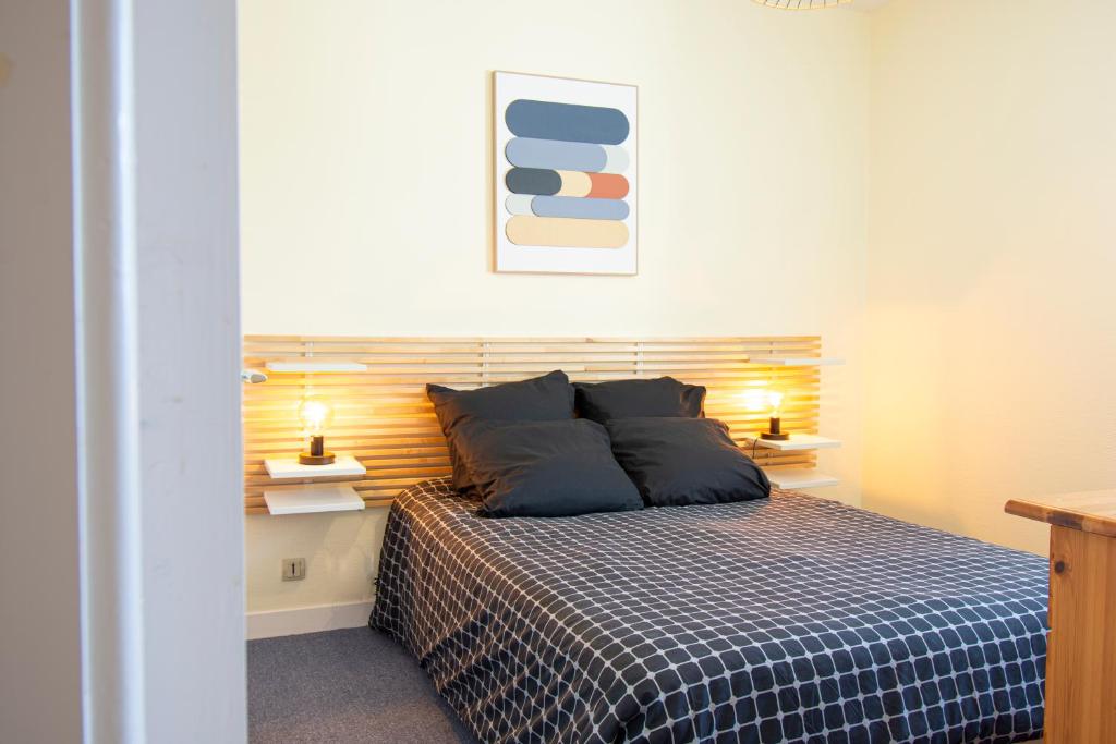 a bedroom with a bed with two pillows on it at Le Franc bord I Plage à 200m in Crozon