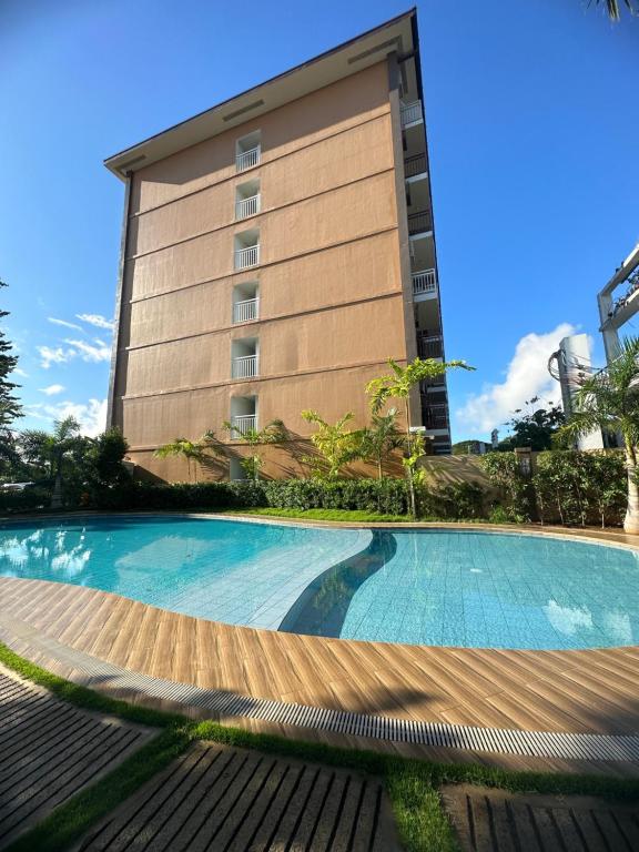 a swimming pool in front of a building at Travel and Lodge Palawan in Puerto Princesa City