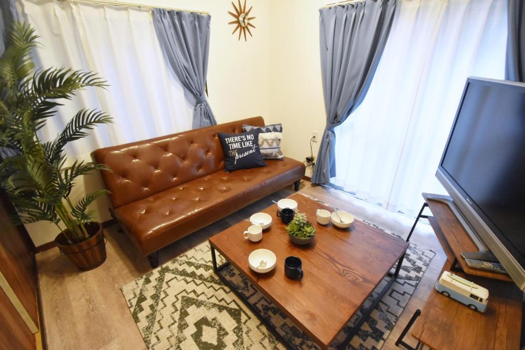 a living room with a couch and a coffee table at Shinozaki Kodate - Vacation STAY 16392 in Tokyo
