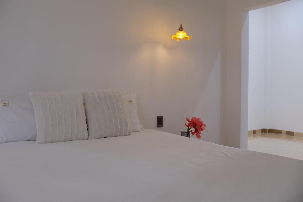 a white bed with white pillows in a bedroom at Gạo Homestay in Mui Ne