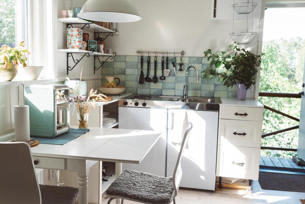 a kitchen with white cabinets and a sink and a window at Woodstock B & B Studios in Bålsta