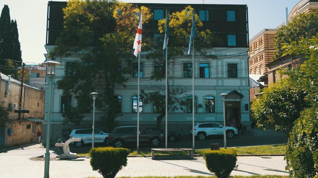 un edificio con due bandiere davanti di EPIGRAPH Design Hotel a Tbilisi City