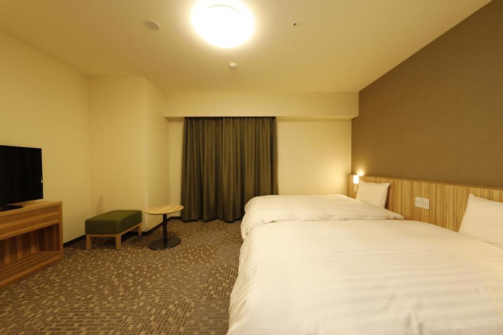 Postel nebo postele na pokoji v ubytování Dormy Inn Maebashi