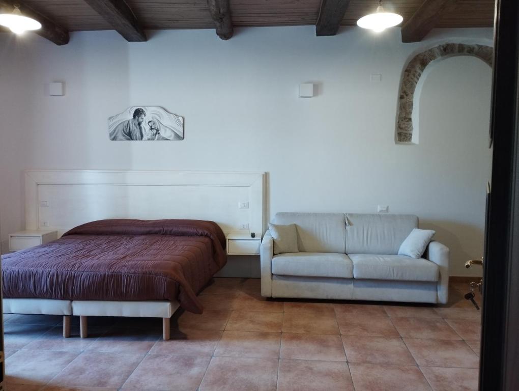 - une chambre avec un lit et un canapé dans l'établissement L'Arco Antico, à Casalbuono
