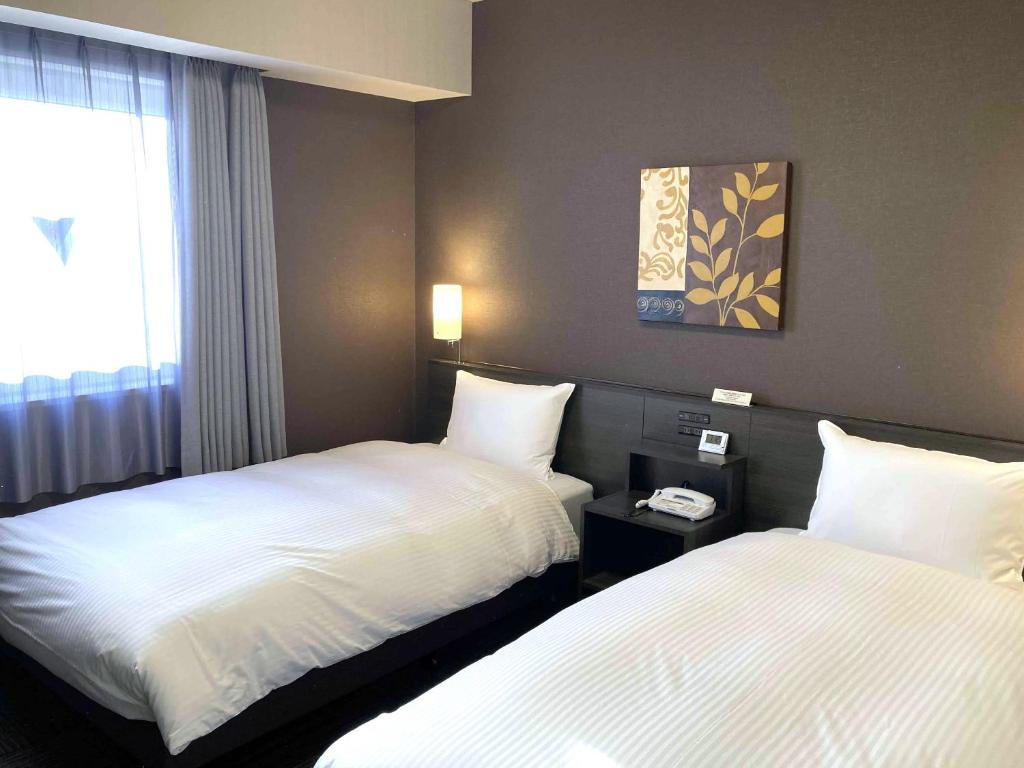 Postel nebo postele na pokoji v ubytování Hotel Route-Inn Kashima